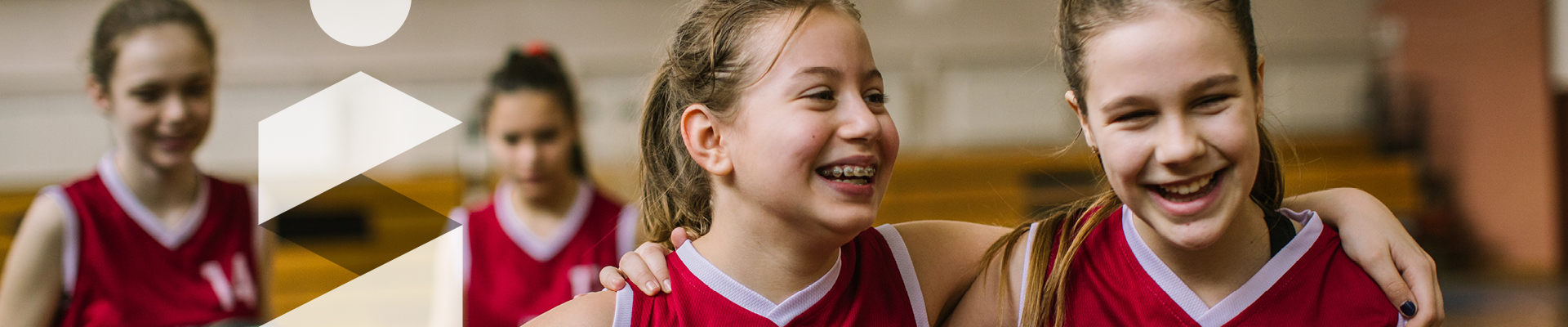 Jeunes joueuses de basketball souriantes se tenant par les épaules