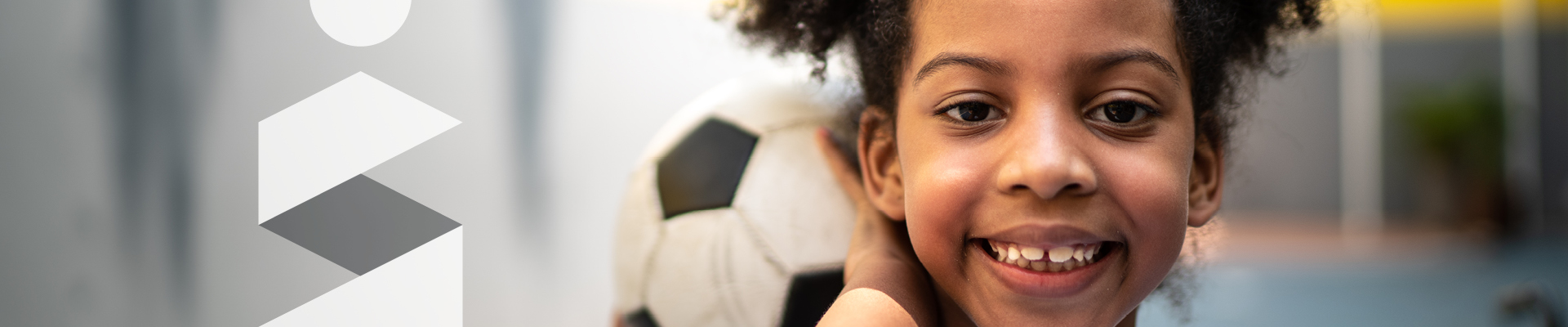 Jeune fille souriante tenant un ballon de soccer